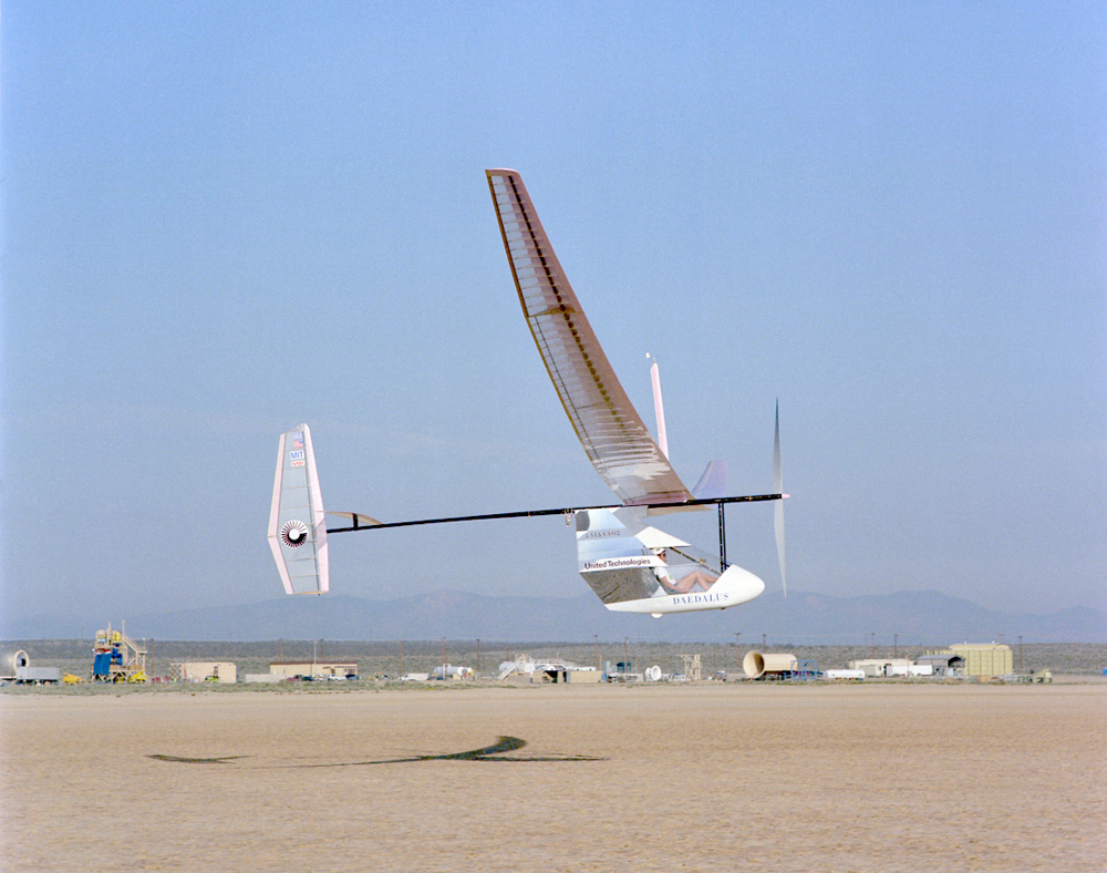 Uma aeronave voando no ar mostrada de fora, que é movida por um mecanismo de acionamento do tipo bicicleta.
