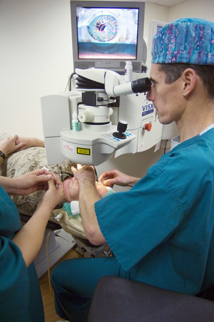 A imagem mostra um cirurgião usando equipamento de última geração para cirurgia LASIK em um paciente deitado.