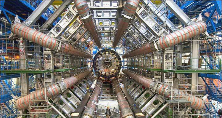 Parte interna do Large Hadron Collider; sistema complexo de máquinas e eletrônicos, com uma pessoa para escalar