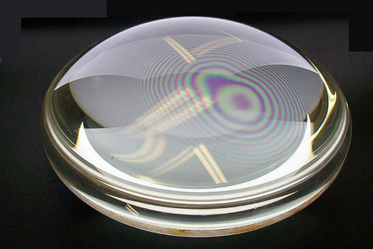 A imagem mostra uma fotografia das franjas de interferência dos “anéis de Newton” produzidas por duas lentes plano-convexas colocadas junto com suas superfícies planas em contato.