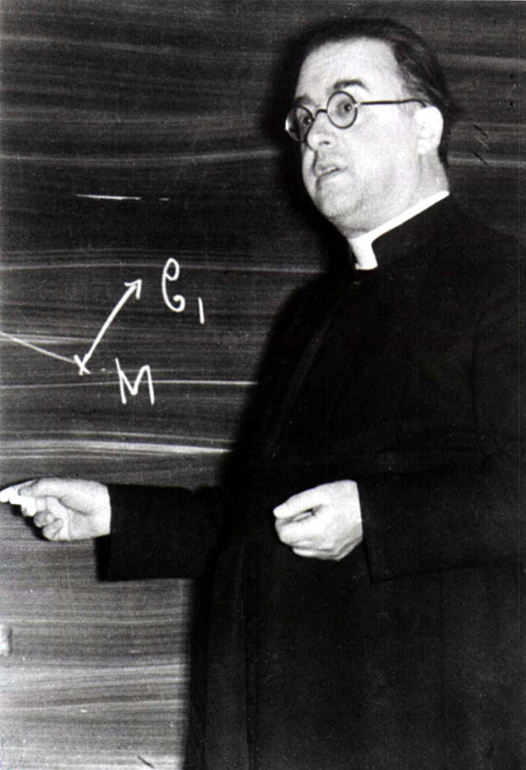 Georges Lemaître is shown writing on a chalkboard.