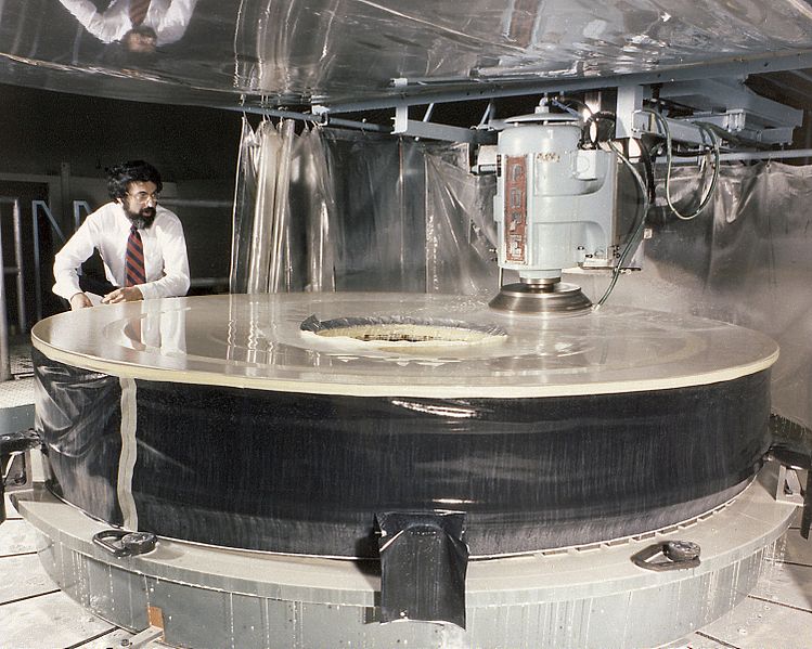 A man is working on Hubble’s enormous primary mirror during fabrication.