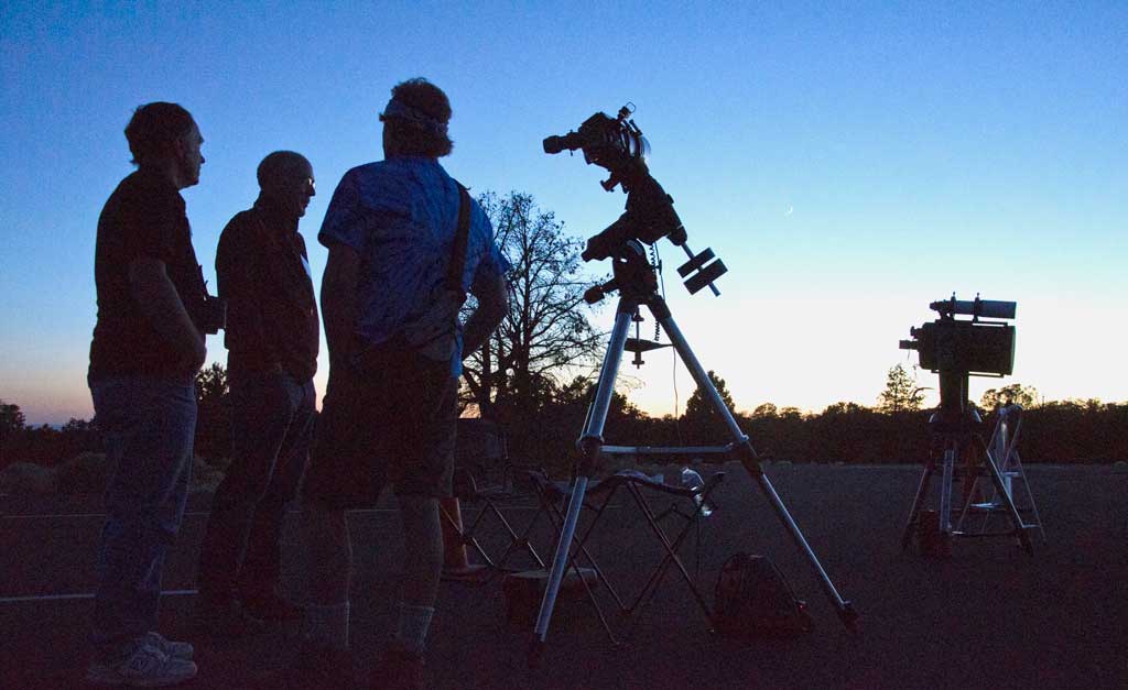 Three men are shown next to equipment at a star party in the Grand Canyon National Park.
