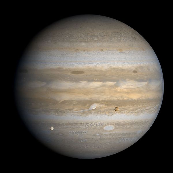 A Voyager 1 image of Jupiter, showing the many storms in the Jovian atmosphere, as well as two of Jupiter’s moons (Europa on the left, Io on the right).
