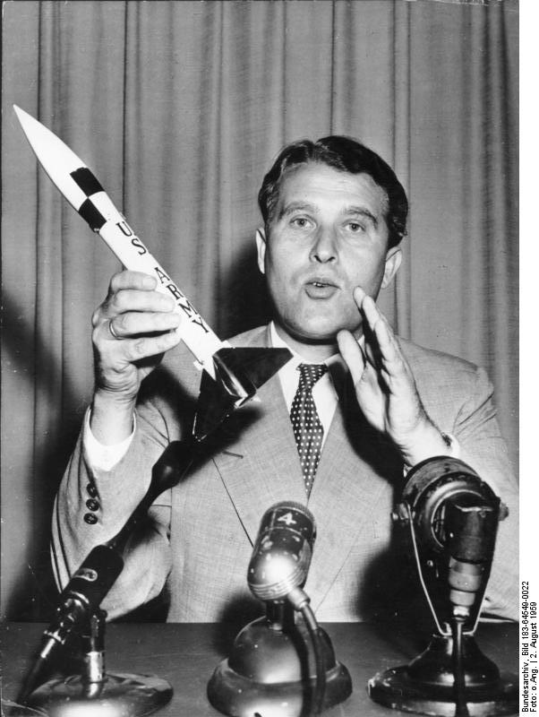 After building rockets as weapons for the Germans in WW II, Wernher von Braun defected to the United States and helped build rockets for America's early space program. https:/commons.wikimedia.org/wiki/File:Bundesarchiv_Bild_183-64549-0022,_Wernher_von_Braun.jpg; 