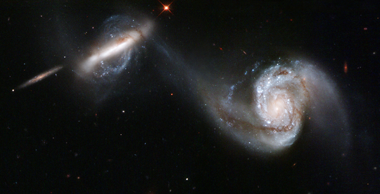 Duas galáxias espirais mostram a forte atração gravitacional entre elas quando seus braços parecem se estender um em direção ao outro.
