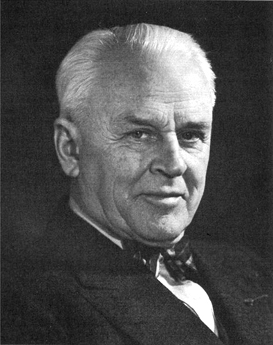 Imagem em preto e branco do físico Robert Millikan vestindo uma jaqueta e uma gravata borboleta.