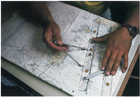 A photograph of someone measuring distance on a map using calipers and a ruler.