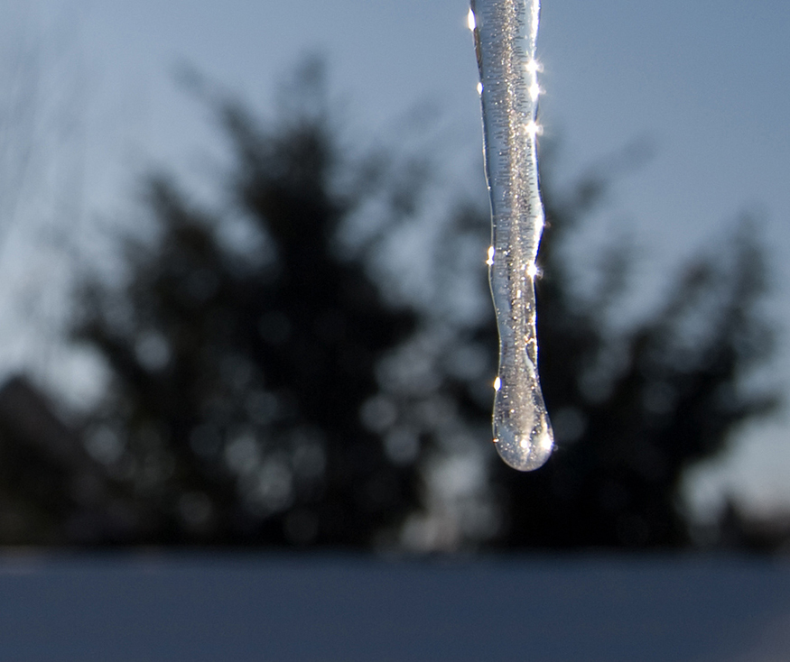 A figura apresentada mostra um pedaço de gelo verticalmente para baixo, em forma de faca, com gotículas de água brilhando em sua superfície.
