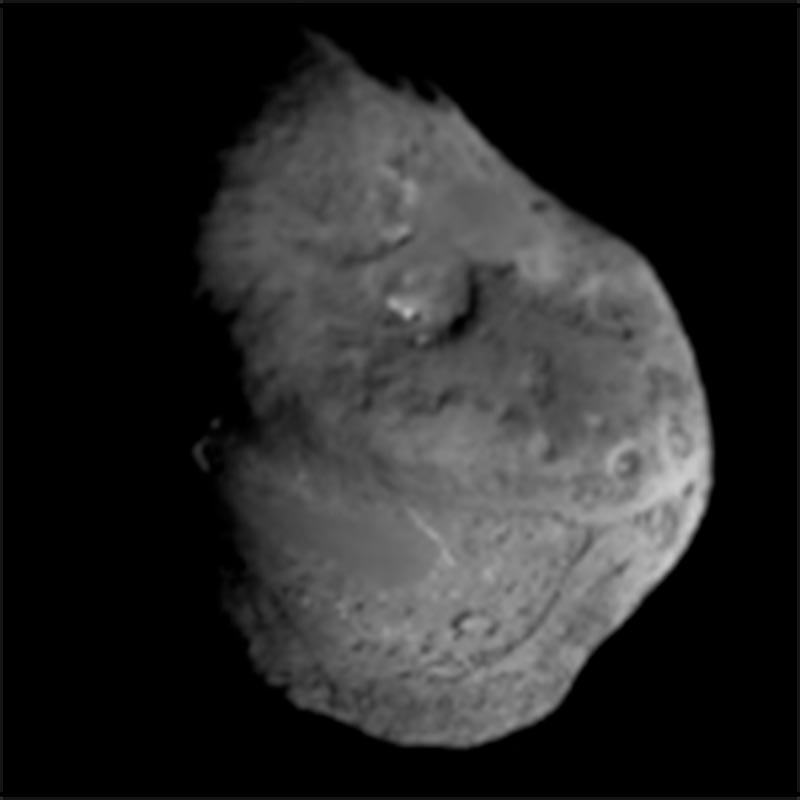 A photograph of the Tempel-1 comet nucleus, taken by the NASA Deep impact spacecraft, which shows an irregular-shaped and impacted body.