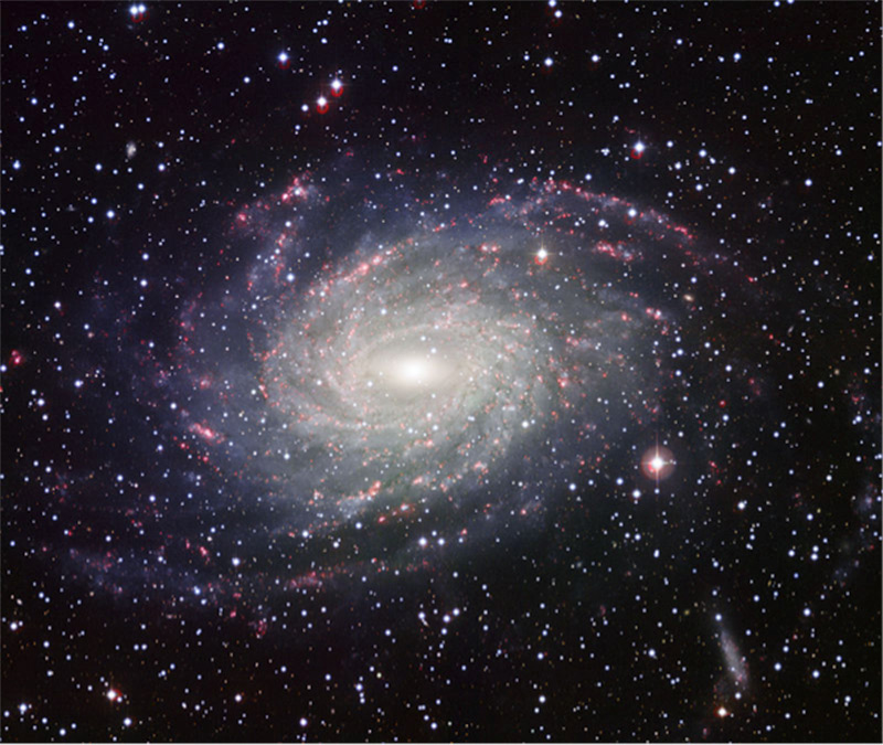 This large barred spiral galaxy is believed to be similar in shape to the Milky Way Galaxy. Dust lanes, spiral arms, and a bar at the galaxy’s center are visible.