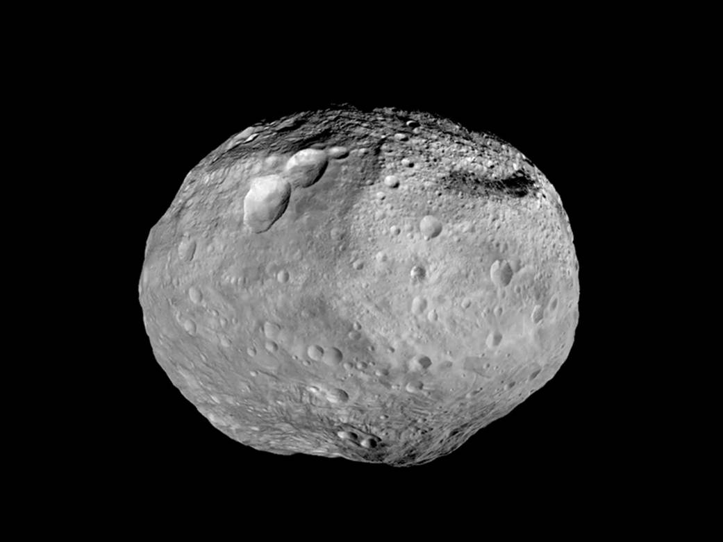 Image of Asteroid (4) Vesta, which is heavily cratered and shaped like a watermelon.