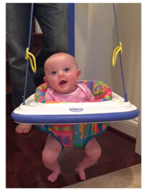 A photo of a baby in a hanging bouncer.
