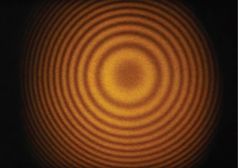 A imagem mostra uma fotografia das franjas produzidas com um interferômetro Michelson. As franjas são visíveis como círculos escuros e claros alternados.