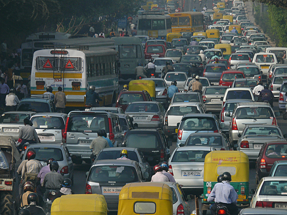 Fotografia de uma estrada congestionada com o tráfego de todos os tipos de veículos.