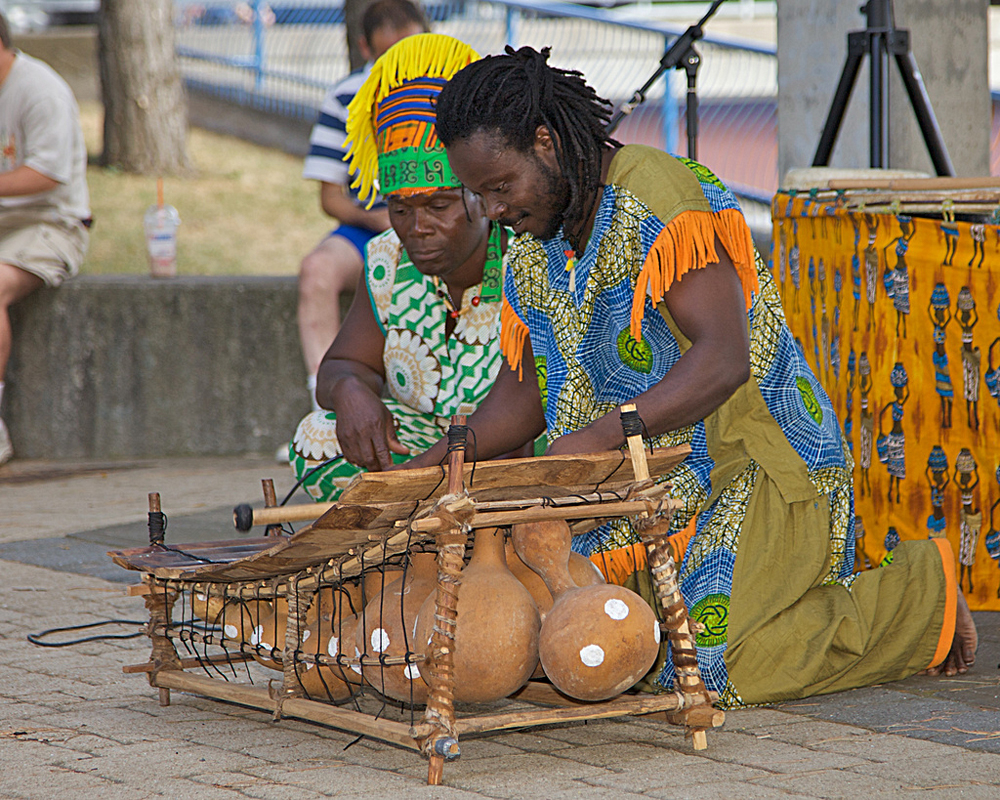 Fotografia de duas pessoas tocando marimba com cabaças como câmaras de ressonância.