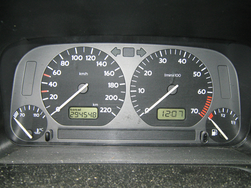 Esta fotografia mostra os instrumentos em um painel cinza do Volkswagen Vento, incluindo o velocímetro, o odômetro e os medidores de combustível e temperatura, mostrando algumas leituras.
