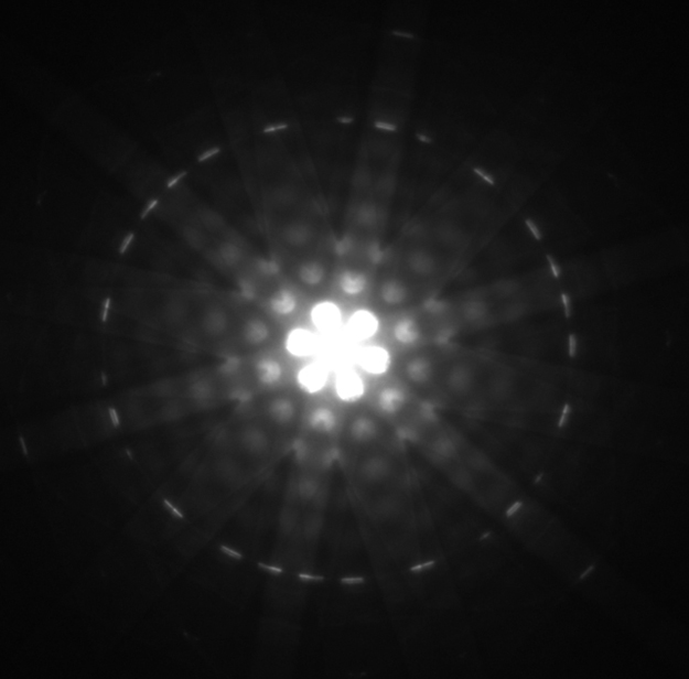 O padrão de difração obtido para elétrons difratados por silício cristalino é mostrado. O padrão de difração tem um ponto brilhante no centro de um círculo com regiões mais claras e mais escuras ocorrendo de forma simétrica.