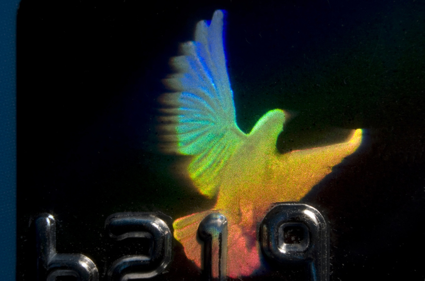 A imagem mostra um holograma da cor do arco-íris de um pássaro em um cartão de crédito.