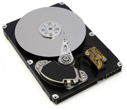 La photo montre l'intérieur d'un disque dur. Le disque argenté contient les informations, tandis que le stylet fin situé sur le dessus du disque lit et écrit les informations sur le disque.