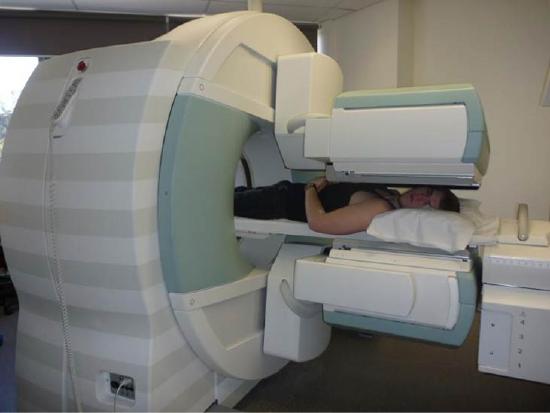 A photograph of a person lying in an imaging machine.