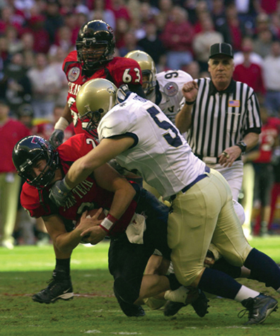A photo of a football player tackling an opponent.